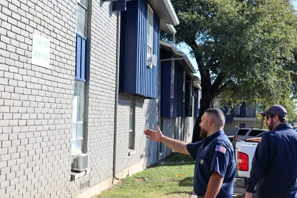 NewRise technicians assessing equipment outside a building