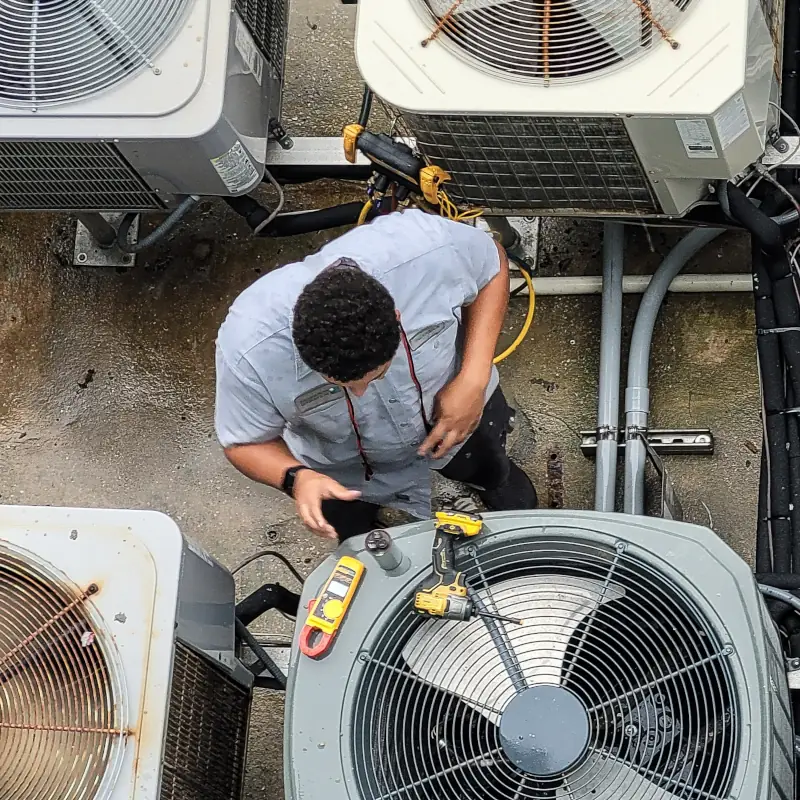 HVAC technician working on rooftop AC Units