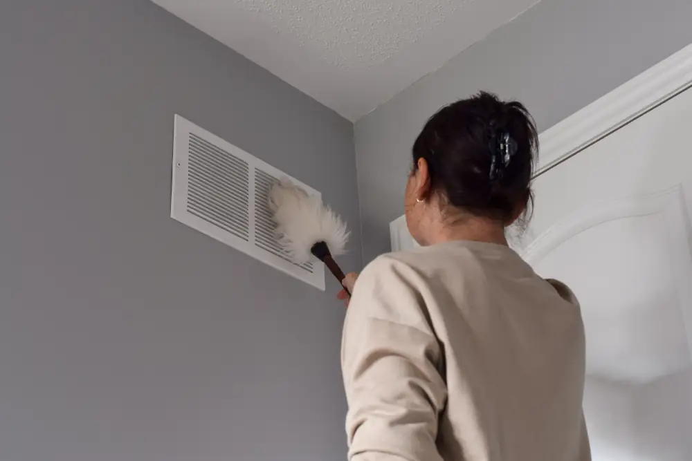 The Importance of Duct Cleaning - Woman cleaning vents.