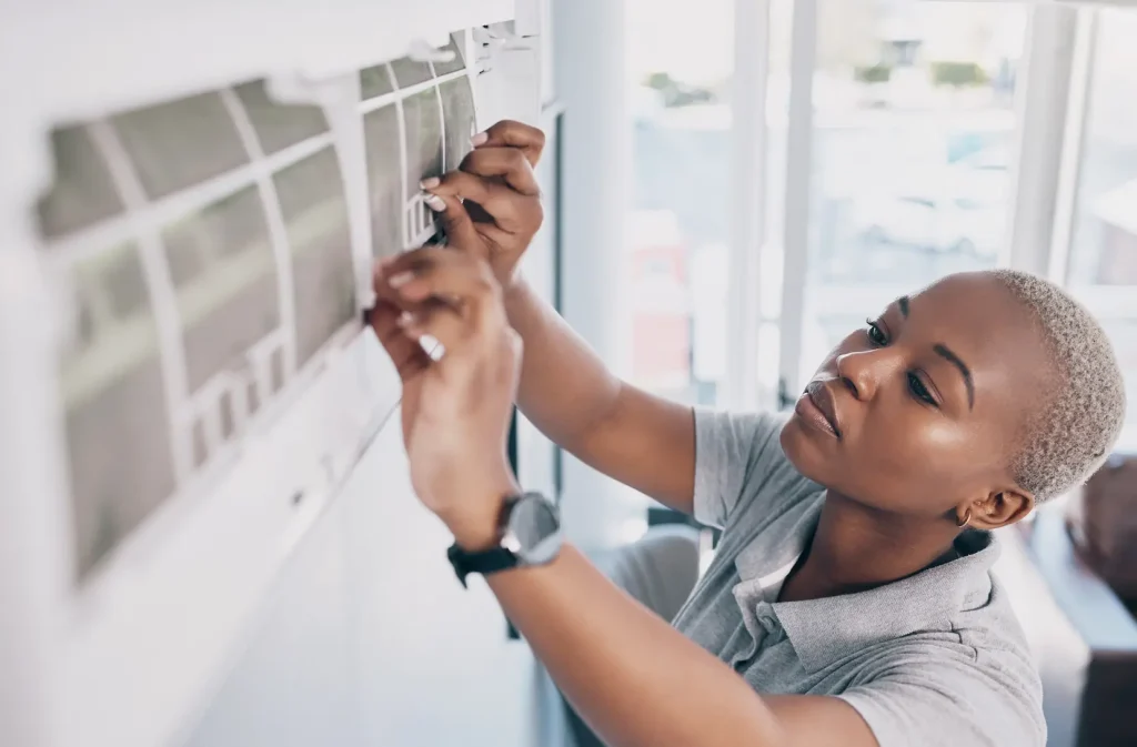 woman performing maintenance on an ac